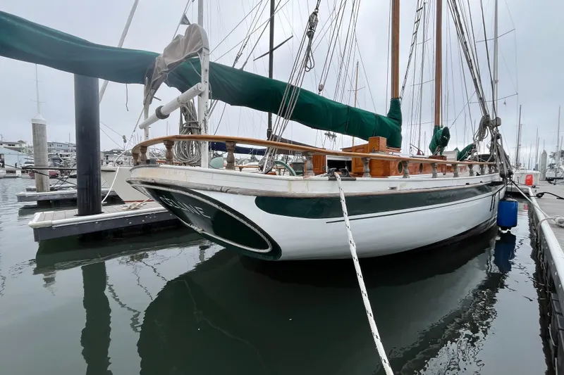 Slide: The Image of Vintage 1947 Murray Peterson Schooner docked at marina, featuring classic wooden design. - 51