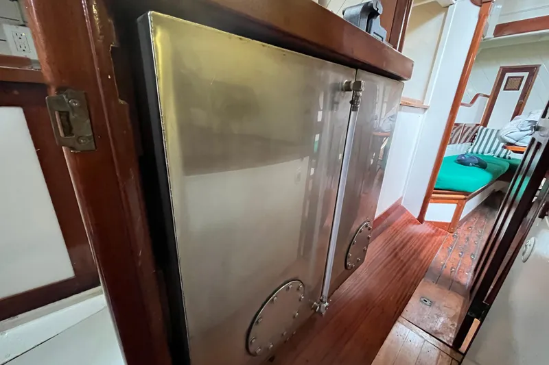 Slide: The Image of Interior of 1947 Murray Peterson Schooner with polished metal cabinetry and wooden flooring. - 79