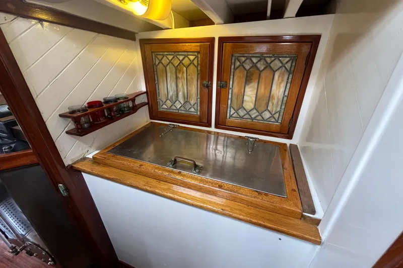 Slide: The Image of Vintage 1947 Murray Peterson Schooner interior with stained glass cabinets and wooden accents. - 80