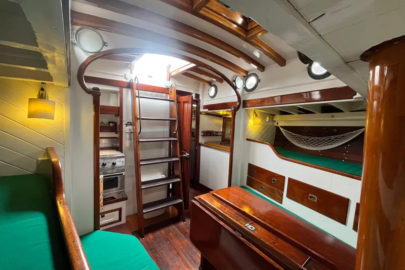 Slide: The Image of Interior of a 1947 Murray Peterson Schooner with wooden finishes and green seating. - 84