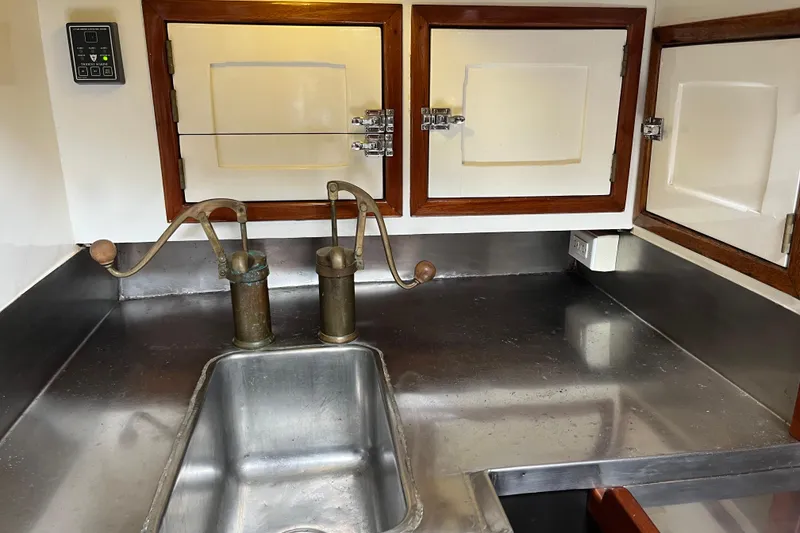 Slide: The Image of Vintage 1947 Murray Peterson Schooner galley with stainless steel sink and wooden cabinets. - 88