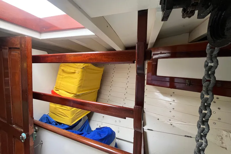 Slide: The Image of Interior of 1947 Murray Peterson Schooner with wooden beams, storage bags, and anchor chain. - 98