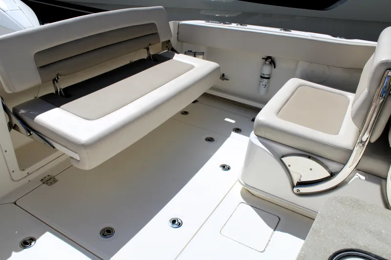 Slide: The Image of 2021 Boston Whaler 320 Vantage interior seating area with beige cushions. - 19