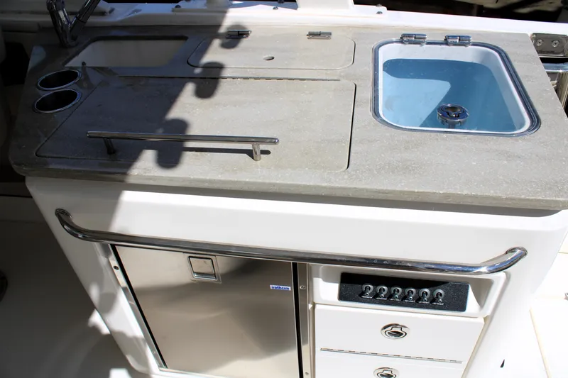 Slide: The Image of 2021 Boston Whaler 320 Vantage boat kitchenette with sink, storage, and control panel. - 28