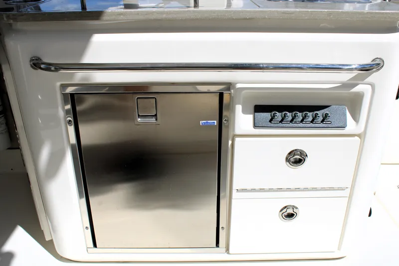 Slide: The Image of 2021 Boston Whaler 320 Vantage boat interior with stainless steel fridge and control panel. - 29
