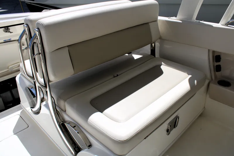 Slide: The Image of 2021 Boston Whaler 320 Vantage boat seating with beige cushions and stainless steel accents. - 31
