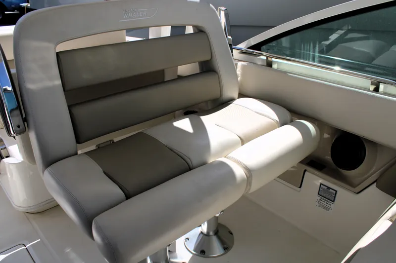 Slide: The Image of 2021 Boston Whaler 320 Vantage boat seat with beige upholstery and stainless steel accents. - 40