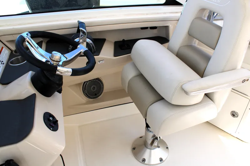 Slide: The Image of 2021 Boston Whaler 320 Vantage helm with steering wheel and cushioned captain's chair. - 42