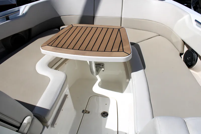 Slide: The Image of 2021 Boston Whaler 320 Vantage boat interior with cushioned seating and wooden table. - 52