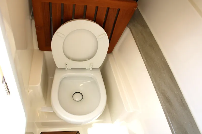 Slide: The Image of 2021 Boston Whaler 320 Vantage boat toilet interior with wooden accents. - 55
