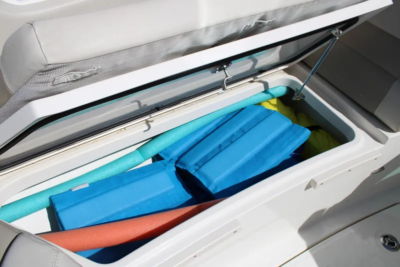 Slide: The Image of Storage compartment on 2021 Boston Whaler 320 Vantage with pool noodles and life jackets. - 64
