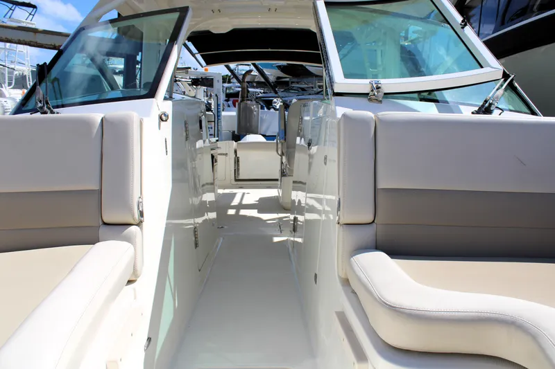 Slide: The Image of 2021 Boston Whaler 320 Vantage boat interior with beige seating and glass windshields. - 65