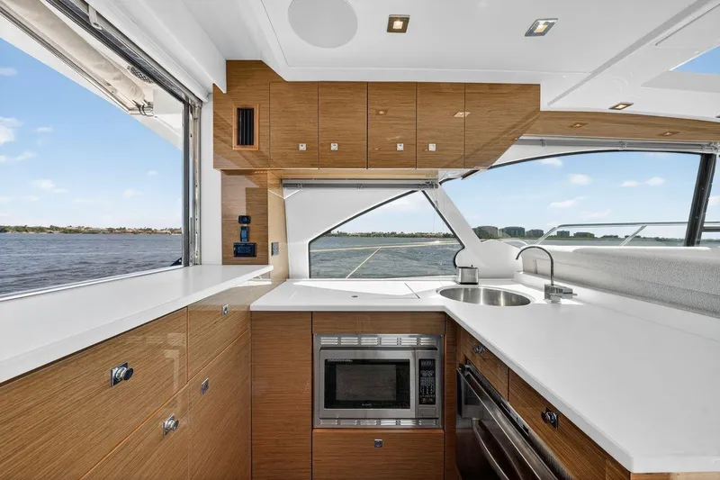 Slide: The Image of Luxurious 2020 Cruisers Yachts 50 Cantius kitchen with modern appliances and scenic water view. - 24