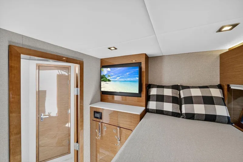 Slide: The Image of 2020 Cruisers Yachts 50 Cantius cabin with TV, bed, and wooden interior. - 43