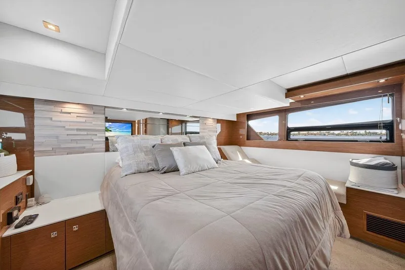 Slide: The Image of Luxurious bedroom interior of 2020 Cruisers Yachts 50 Cantius with elegant bedding and scenic window view. - 50