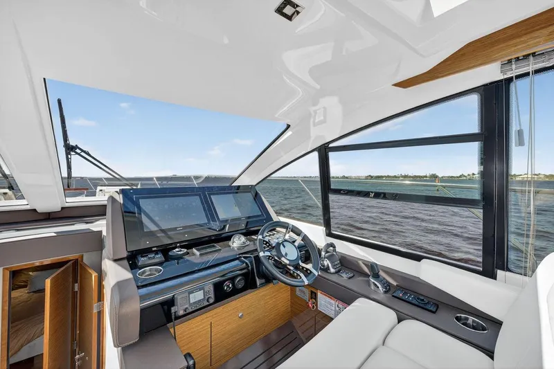 Slide: The Image of 2020 Cruisers Yachts 50 Cantius helm with modern controls and panoramic water view. - 26