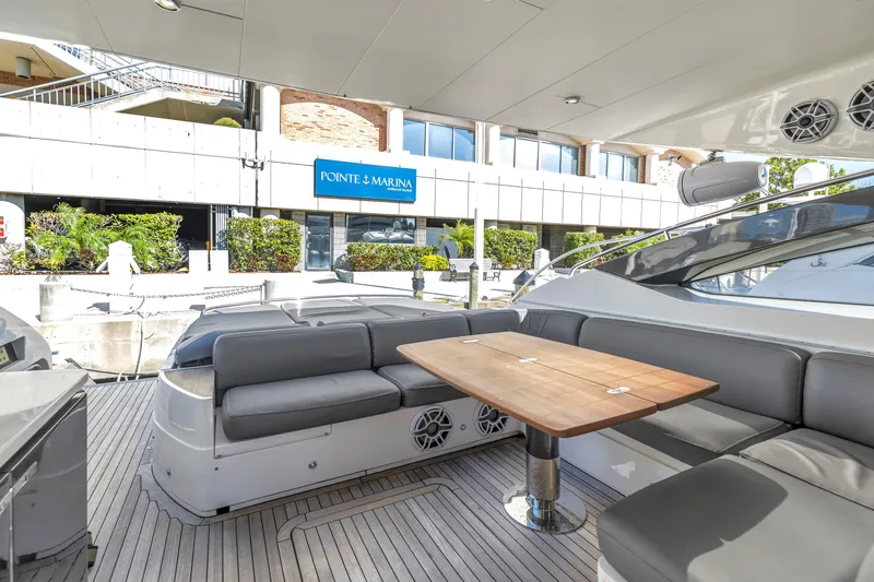 Slide: The Image of Luxurious 2013 Princess V57 yacht with elegant seating and wooden table at a marina. - 30