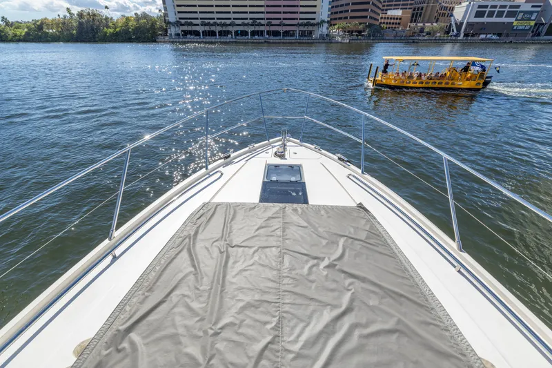 Slide: The Image of Bow view of 2013 Princess V57 yacht on a sunny day, with cityscape and water taxi. - 36
