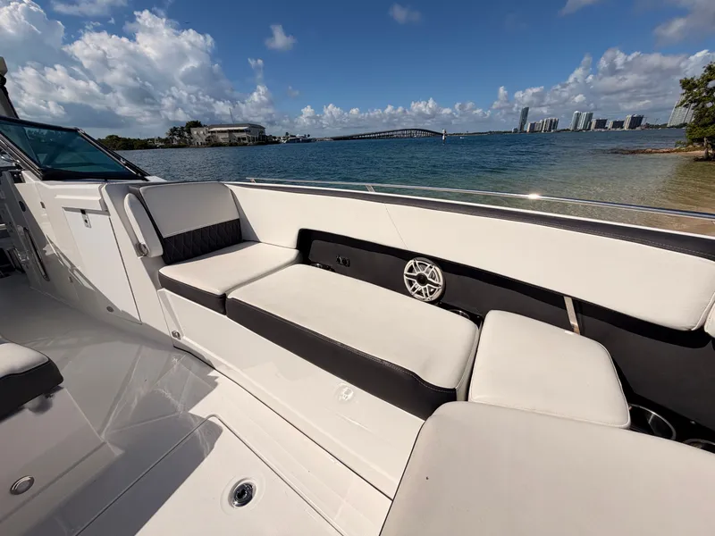 Slide: The Image of 2017 Monterey 378 Super Express boat interior with white seating, overlooking a scenic waterfront. - 10