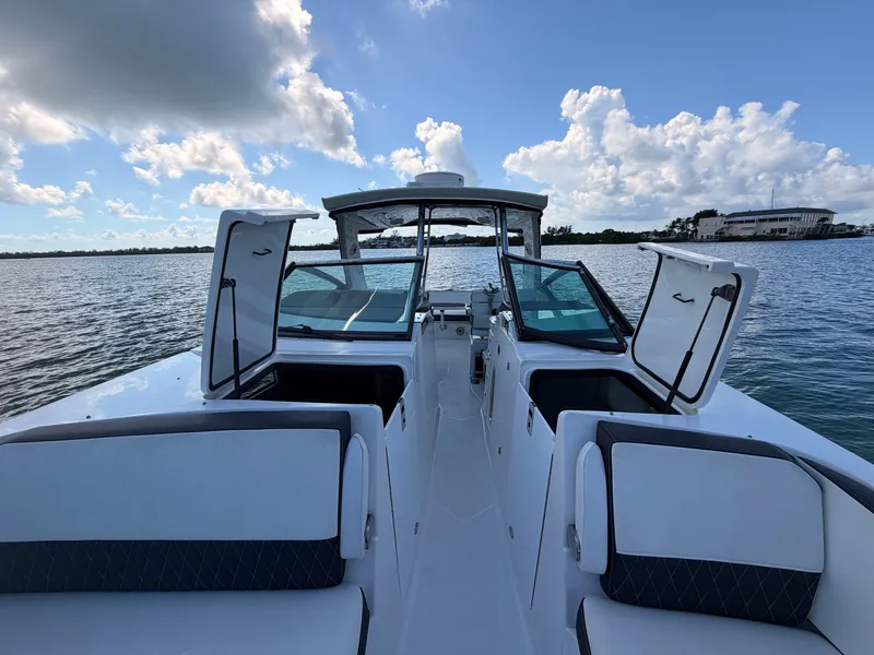Slide: The Image of 2017 Monterey 378 Super Express boat on water, open hatches, clear sky, and distant shoreline. - 17