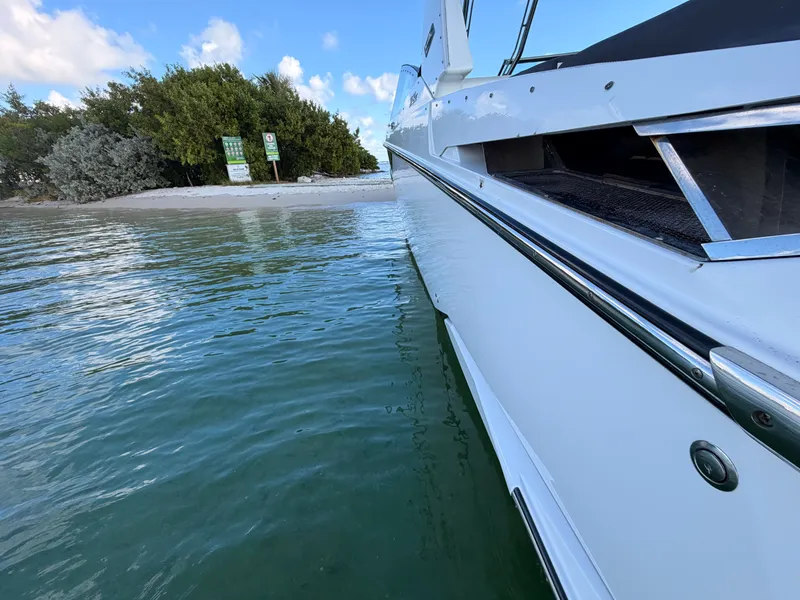 Slide: The Image of 2017 Monterey 378 Super Express yacht near a sandy beach and lush greenery. - 6