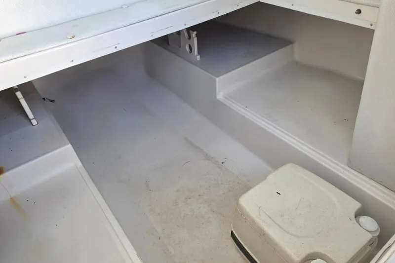Slide: The Image of 1999 Sport-Craft 230 boat interior with white seating and storage area. - 11