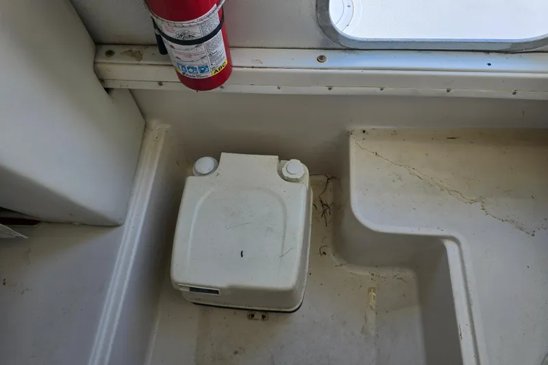 Slide: The Image of 1999 Sport-Craft 230 boat interior with fire extinguisher and storage compartment. - 12