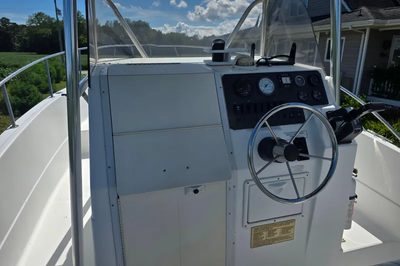 Slide: The Image of 1999 Sport-Craft 230 boat dashboard with steering wheel and control panel. - 13