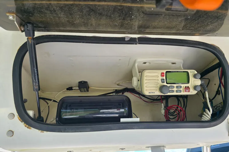 Slide: The Image of 1999 Sport-Craft 230 boat electronics compartment with radio and wiring. - 14