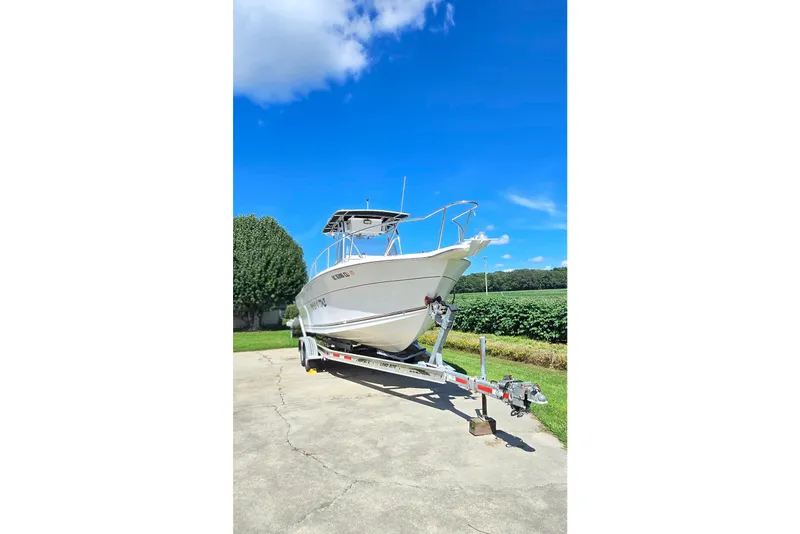 Slide: The Image of 1999 Sport-Craft 230 boat on trailer under clear blue sky. - 18