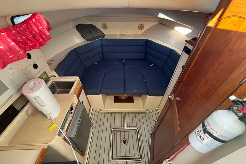 Slide: The Image of Interior of 2001 Albin 28 Tournament Express with blue seating and kitchenette. - 16