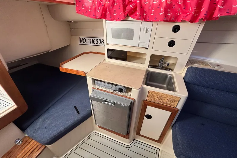 Slide: The Image of 2001 Albin 28 Tournament Express cabin with kitchenette, sink, and seating area. - 17