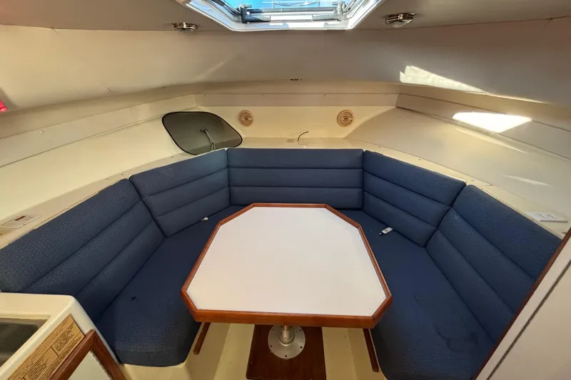 Slide: The Image of 2001 Albin 28 Tournament Express cabin with blue seating and hexagonal table. - 19