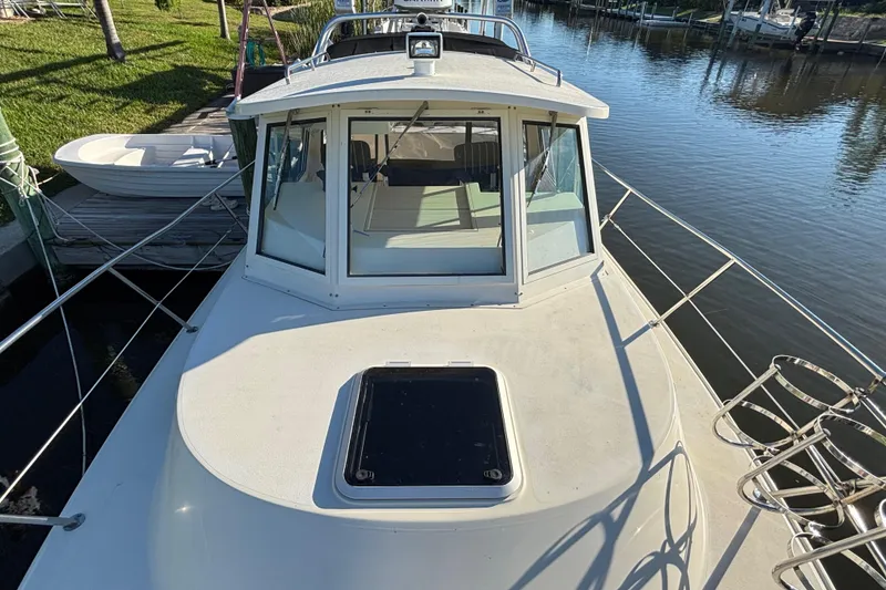 Slide: The Image of 2001 Albin 28 Tournament Express boat docked by a calm waterfront. - 8