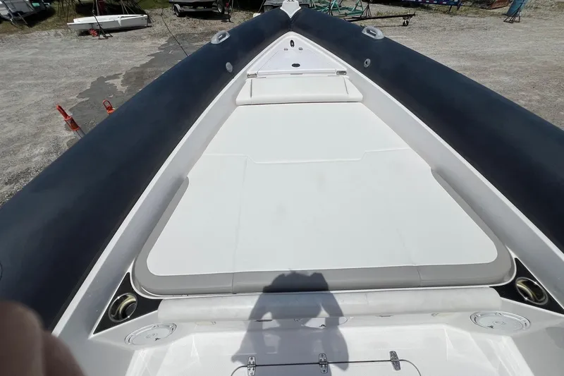 Slide: The Image of 2015 Airship 330 boat deck with seating, docked on gravel surface. - 10