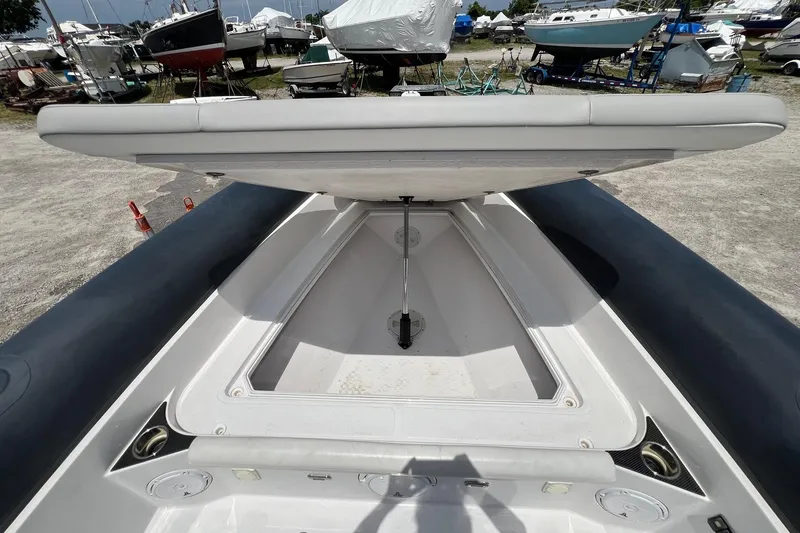 Slide: The Image of Open storage compartment on 2015 Airship 330 boat, with surrounding boats in a marina. - 11