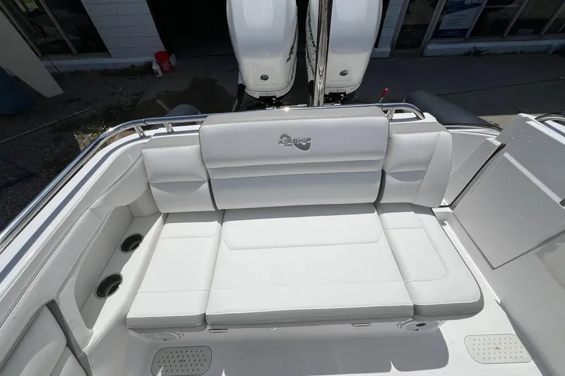 Slide: The Image of White seating area on 2015 Airship 330 boat, featuring comfortable cushions and cup holders. - 5