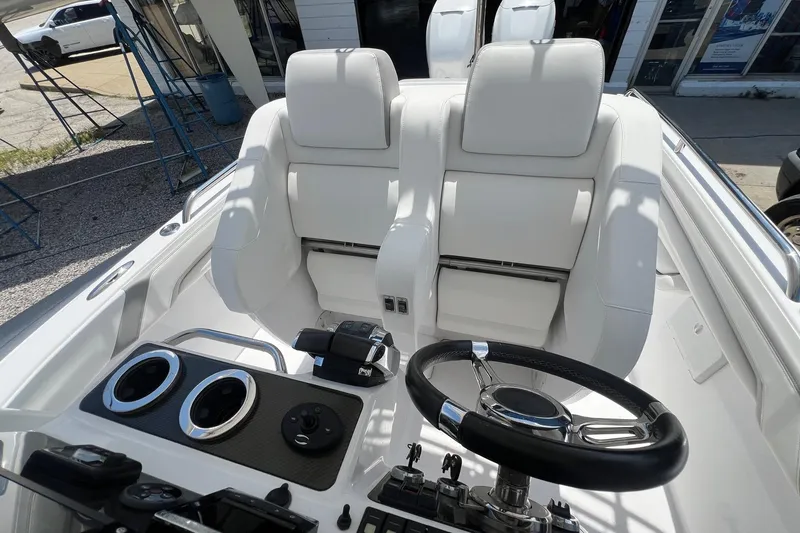 Slide: The Image of Interior of a 2015 Airship 330 boat with white seating and steering wheel. - 7