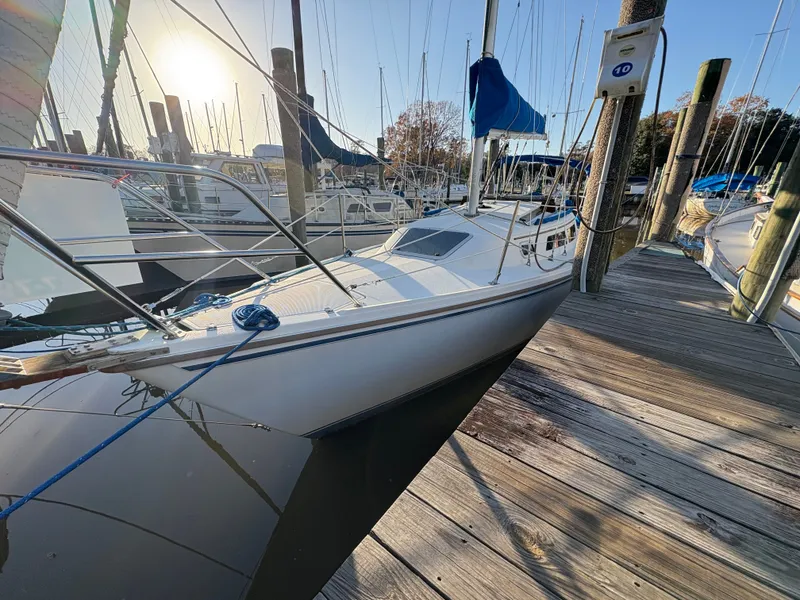 Slide: The Image of 1988 Catalina 27 sailboat docked at marina during sunset. - 12