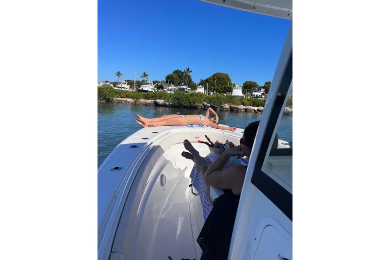 Slide: The Image of 2021 Sea Hunt Gamefish 30 Coffin Box with people relaxing on deck in sunny waters. - 11