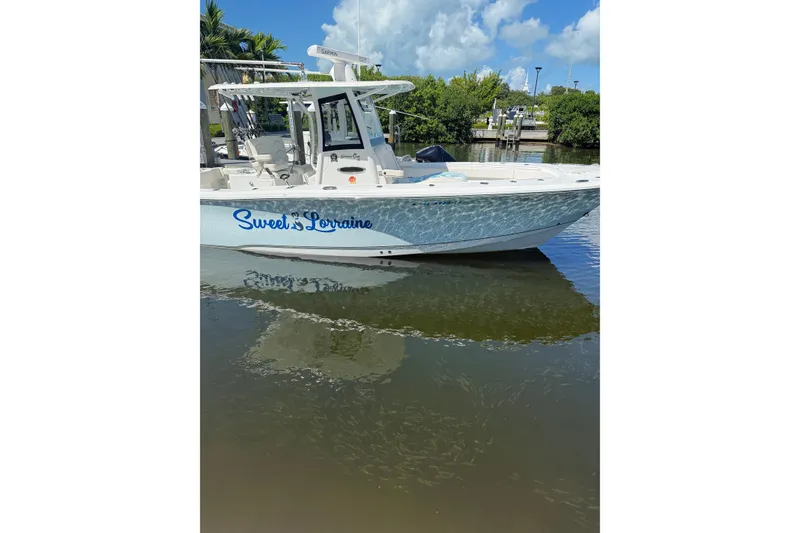 Slide: The Image of 2021 Sea Hunt Gamefish 30 Coffin Box boat named "Sweet Lorraine" docked on calm water. - 18