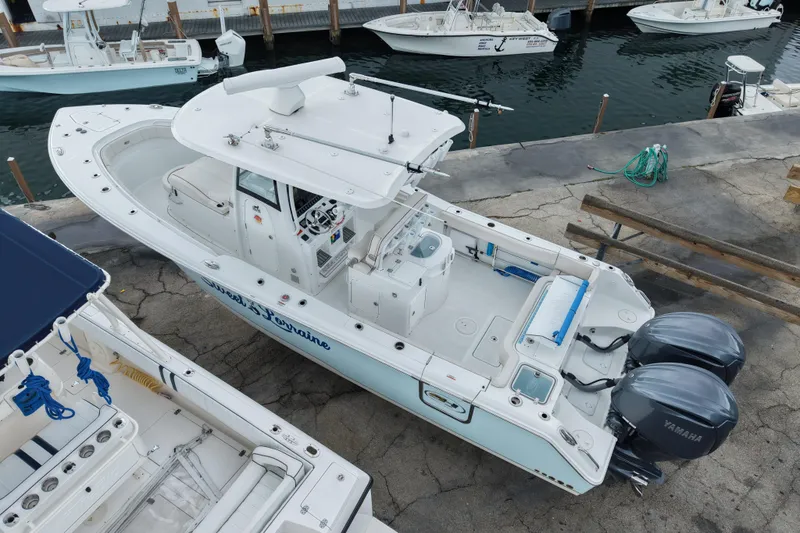 Slide: The Image of 2021 Sea Hunt Gamefish 30 Coffin Box boat docked with twin Yamaha engines. - 21