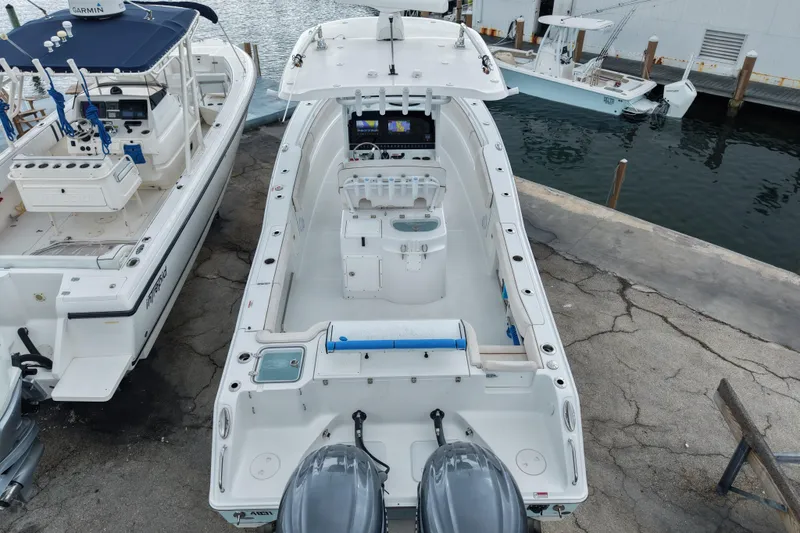 Slide: The Image of 2021 Sea Hunt Gamefish 30 Coffin Box boat docked, featuring dual engines and spacious deck. - 22
