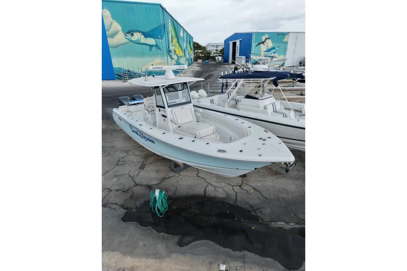 Slide: The Image of 2021 Sea Hunt Gamefish 30 Coffin Box boat docked, with vibrant marine mural background. - 23