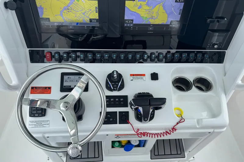 Slide: The Image of 2021 Sea Hunt Gamefish 30 Coffin Box helm with steering wheel, controls, and navigation screens. - 30