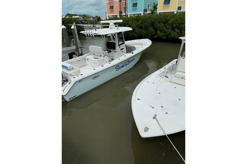 Slide: The Image of 2021 Sea Hunt Gamefish 30 Coffin Box boat, docked under cloudy skies. - 7
