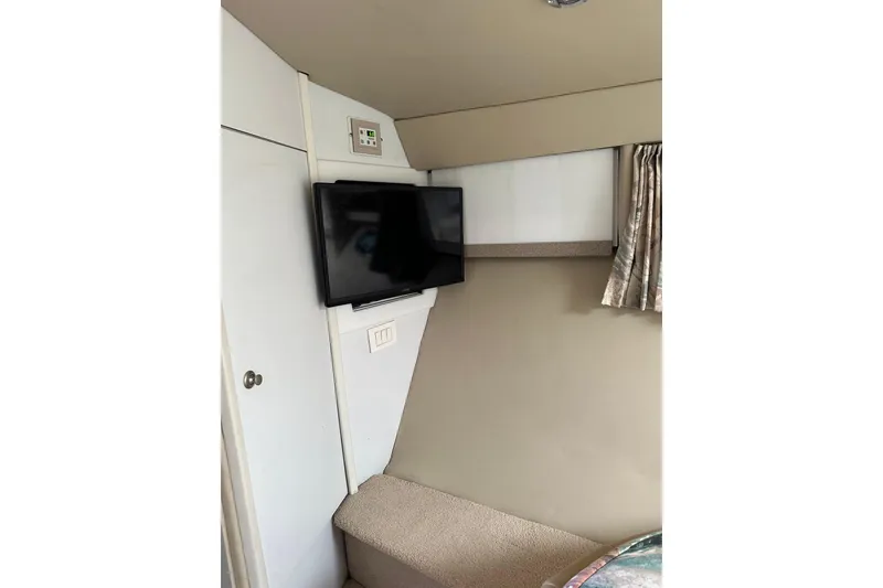 Slide: The Image of Interior of 1997 Formula 41 Performance Cruiser with mounted TV and beige decor. - 20