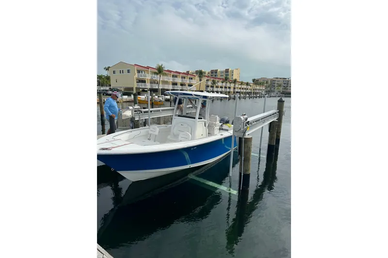 Slide: The Image of 2015 Sea Hunt Gamefish 25 boat docked at marina with waterfront buildings. - 3
