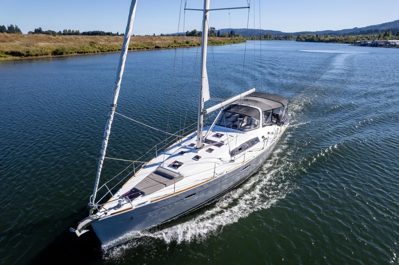 The Image of 2013 Beneteau Oceanis 50 sailing on a serene river under clear skies. - 0