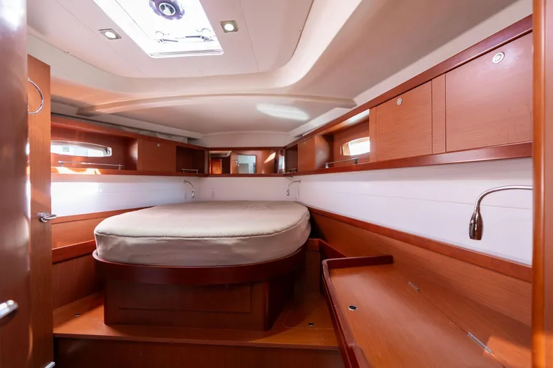 Slide: The Image of Interior cabin of 2013 Beneteau Oceanis 50 yacht, featuring wood finish and cozy bed. - 16